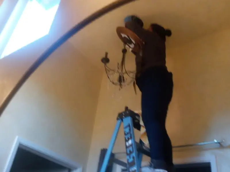 Electrician installing a chandelier in a West Valley City residence